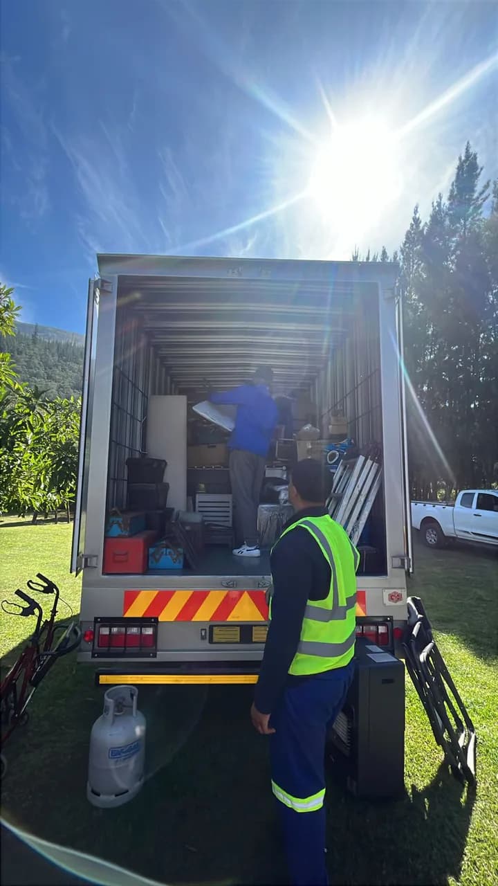 Two people offloading items from a box truck during a GPC moving operation.